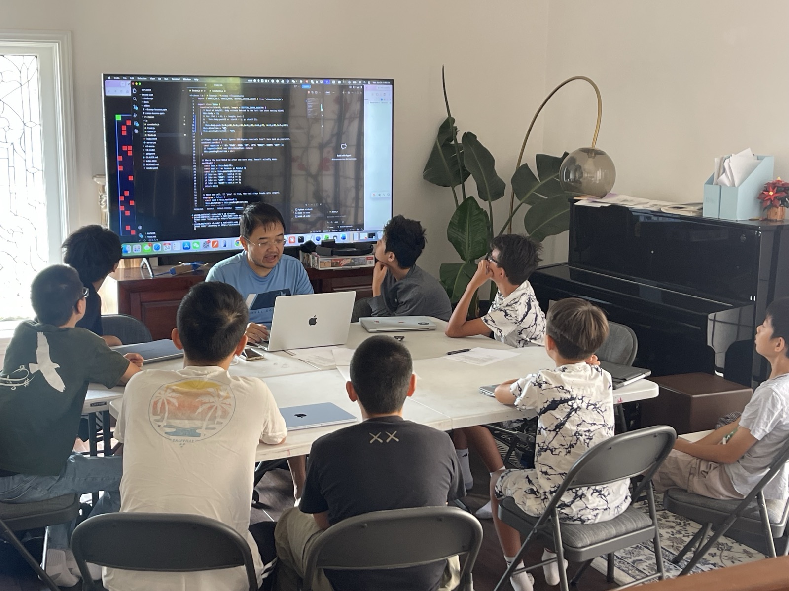 Snake-Lab AI Camp in session — an instructor walking students through bot code